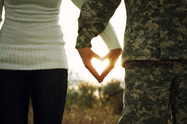 Photo of a Soldier and his love making a heart