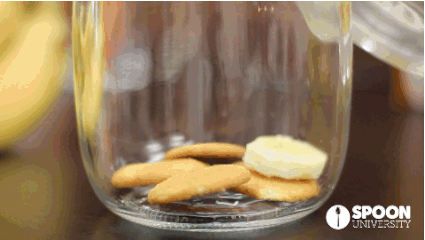 Siapkan gelas jar yang dasarnya telah diisi biskuit dan potongan pisang secara berlapis. Kemudian siram dengan adonan puding+whipped cream di atasnya. (Via: spoonuniversity.com) 
